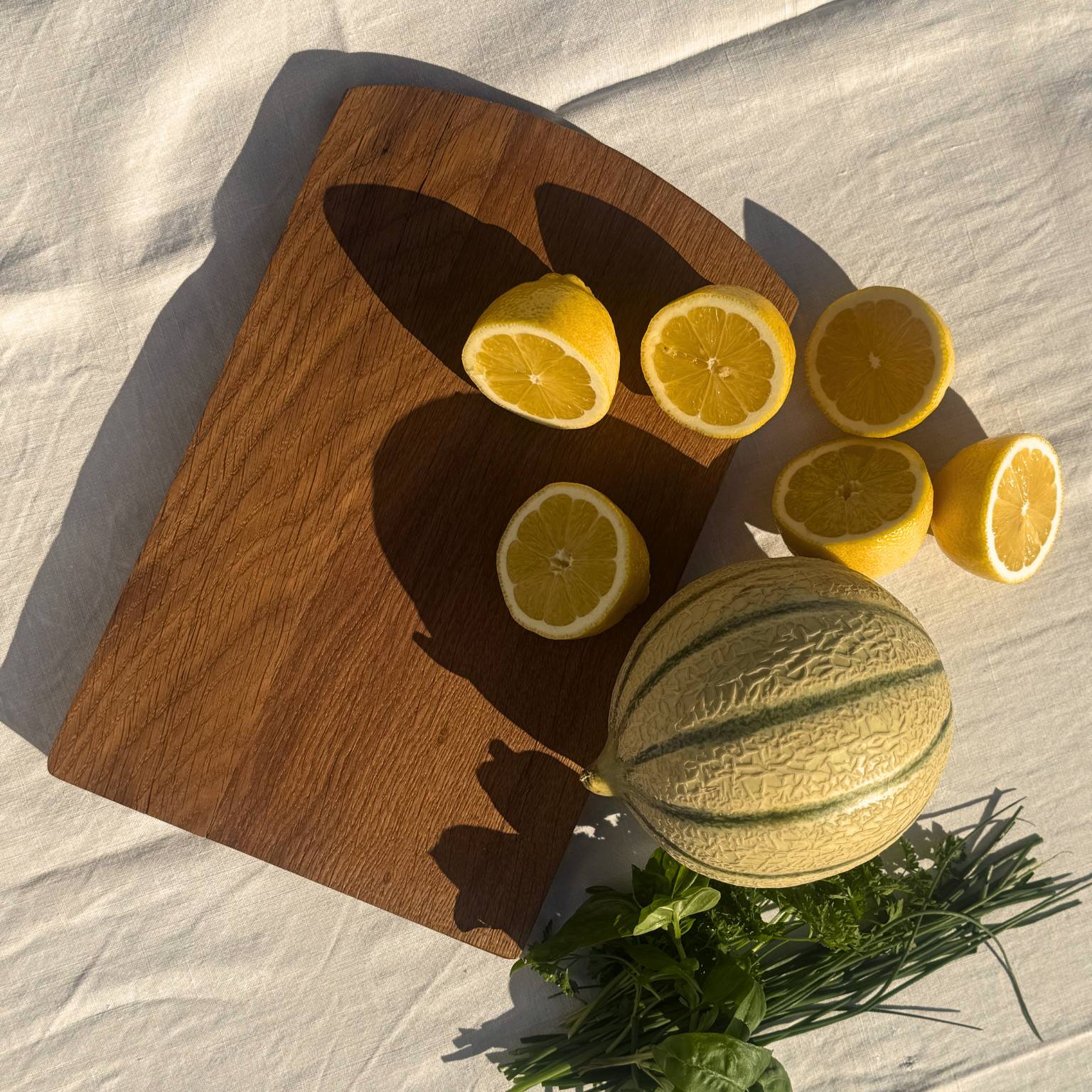 planche à découper en bois de chêne, vue d'en haut, citrons et melon